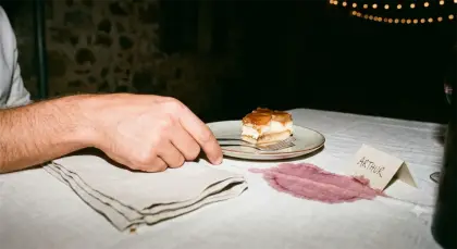Une part de gâteau, une tache de vin sur la nappe et un marque-place au nom d’Arthur.